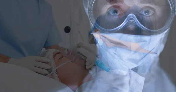病院のベッドに横たわっている患者の上にカメラを見て背景に酸素のマスを身に着けている — ストック写真