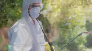Koruyucu giysiler ve yüz maskesi takan, hızlı hareket eden insanların üzerine dezenfektan sıkan bir adamın canlandırması. Küresel halk sağlığı koronavirüsü Covid 19 salgın konsepti dijital kompozit.