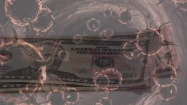 Masaya Amerikan dolarları koyan birinin üzerinde süzülen makro Covid-19 hücrelerinin animasyonu. Finans sektörü borsası küresel veri işleme kavramı dijital olarak oluşturulmuş görüntü.
