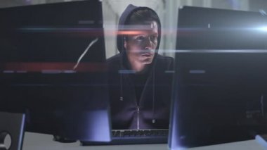 Siyah başlıklı beyaz bir bilgisayar korsanı iki monitörlü bir bilgisayar üzerinde çalışıyor, internet güvenlik ihlali siber suç konsepti, dijital kompozit