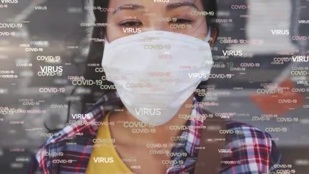 言葉のアニメーション顔のマスクを身に着けている女性の上に浮かんでいるCovid 19ウイルス 世界的なパンデミックコロナウイルスCovid 19感染症の概念をデジタルで生成 — ストック動画
