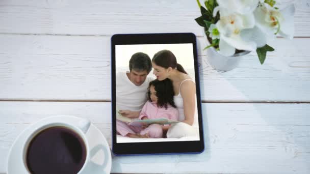 白人の家族が画面上で本を読んで 受け入れていることを示すデジタルタブレットのアニメーション コロナウイルスCovid 19技術コンセプトデジタル組成 — ストック動画