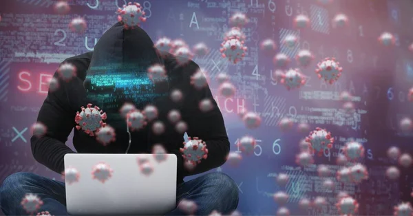 Digital illustration of macro Covid-19 cells floating, data processing, and statistics over a man wearing a hoodie using a laptop. Coronavirus Covid-19 pandemic concept digital composite