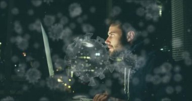 Makro Covid-19 hücrelerinin dijital çizimi beyaz adamın üzerinde yüzüyor, kapüşonlu bir şey giyiyor, dizüstü bilgisayar kullanıyor. Coronavirus Covid-19 pandemik konsept dijital bileşik