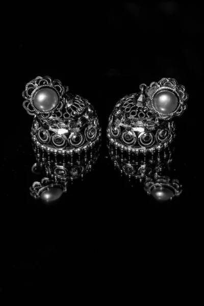 镶嵌有宝石的传统金耳环和有倒影的两只金耳环 金耳环搭配珍珠色的黑色背景 奢华的女性珠宝 — 图库照片