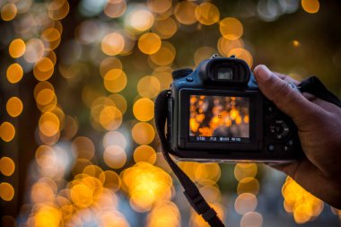Bokeh Arkaplanındaki DSLR Kamerası - Bokeh Işıkları Fotoğraflı Kara DSLR Kamerası ve Kamera Şehir Işıkları Bokeh