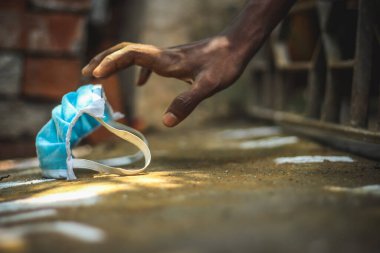 Korunma maskesi, Corona virüsüne karşı el ele tutuşan adamlar enfeksiyon maskesi, sağlık hizmeti konsepti. Fakir insanlar ellerinde mavi yüz maskesi taşıyorlar.