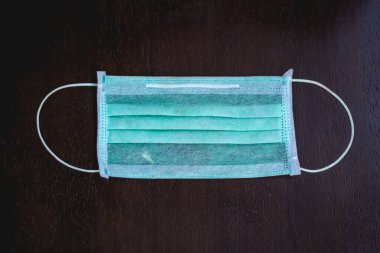 Koruyucu yüz maskesi, Top view 'in karanlık arka planında izole edilmiş. Yüz maskesi talep edilir, bu yüzden her geçen gün daha da artacak.,