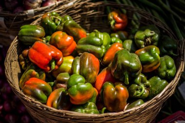 Sokak pazarında kapsicum tel sepet sebze kasesi satmak. Sebze sepetinde satılık kırmızı ve yeşil biber..