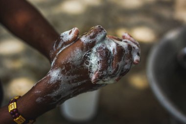 Ellerini yıkıyor. Adam evde ellerini yıkıyor. Coronavirüs salgını önleme ellerini sabunla sıcak suyla yıkıyor ve sık sık tırnaklarını ve parmaklarını yıkıyor. Hijyen & Temizleyici Eller.