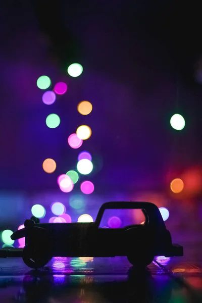 玩具汽车轮廓笼罩在圣诞灯火通明的Bokeh背景上 古董车和Bokeh库存照片 — 图库照片