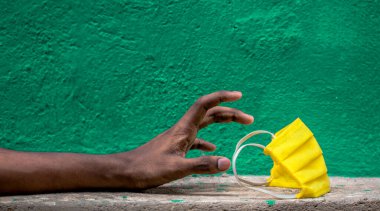 İnsanların yeşil arka planda yüz maskelerine ihtiyaçları var. Bulaşıcı Corona virüsüne (COVID-19) karşı korunma, grip gibi hava yoluyla bulaşan solunum hastalıklarını önlemek için, 2020.