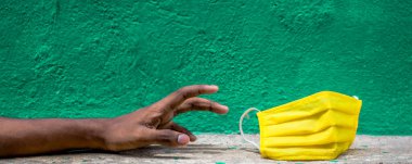 İnsanların yeşil arka planda yüz maskelerine ihtiyaçları var. Bulaşıcı Corona virüsüne (COVID-19) karşı korunma, grip gibi hava yoluyla bulaşan solunum hastalıklarını önlemek için, 2020.