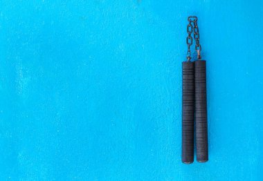 Nunchaku weapon isolated on Blue background. Black nunchaku training for beginner. Hot Tactical Gear Martial Arts Equipments. clipart