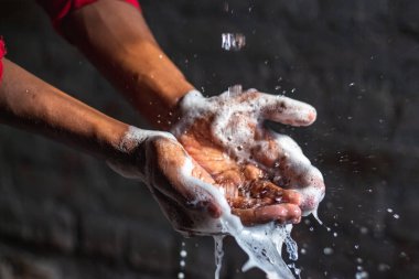 Ellerini yıkıyor. Evdeki bahçede ellerini yıkayan bir adam. Corona virüsü salgını önleme sabunla, sıcak suyla, ovalayarak ve tırnaklarla sık sık yıkanarak ellerini yıkar. Hijyen & Temizleyici Eller.
