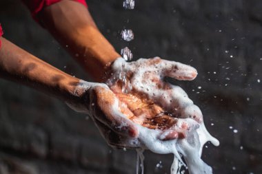 Ellerini yıkıyor. Evdeki bahçede ellerini yıkayan bir adam. Corona virüsü salgını önleme sabunla, sıcak suyla, ovalayarak ve tırnaklarla sık sık yıkanarak ellerini yıkar. Hijyen & Temizleyici Eller.