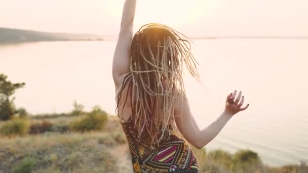 Atrakcyjna hipisowska kobieta z dredami o zachodzie słońca — Wideo stockowe