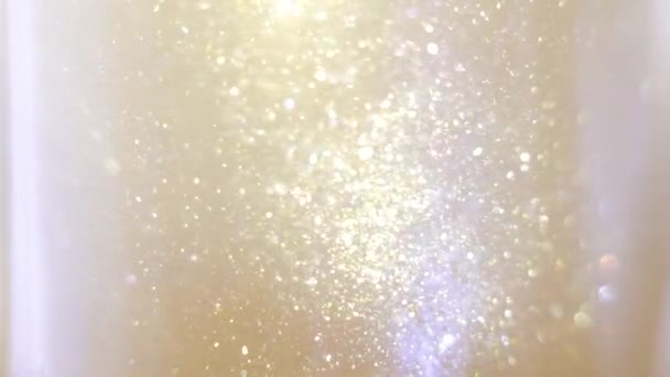 Close up de brilho flutuando em vodka colorido pintura dourada mistura em tinta de água — Vídeo de Stock