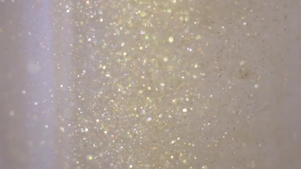 Gros plan de paillettes flottant dans la vodka couleur or mélange de peinture à l'encre d'eau — Video