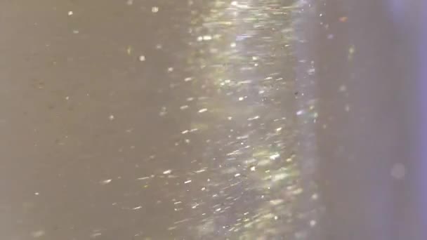 Gros plan de paillettes flottant dans la vodka couleur or mélange de peinture à l'encre d'eau — Video