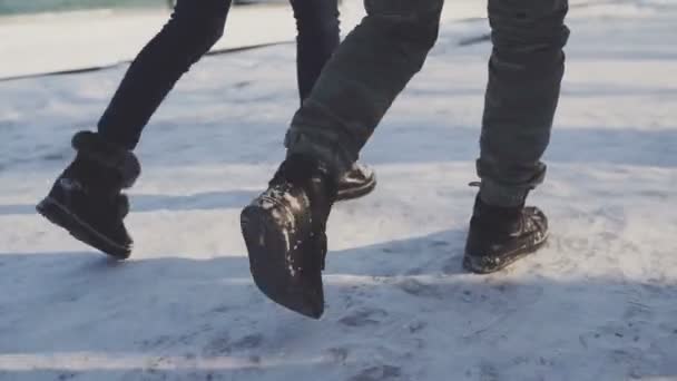 Ноги пешком по снегу друзья ходят по снежной дороге — стоковое видео