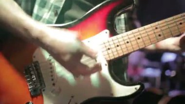 Gitarist sahnede elektro gitar çalıyor.
