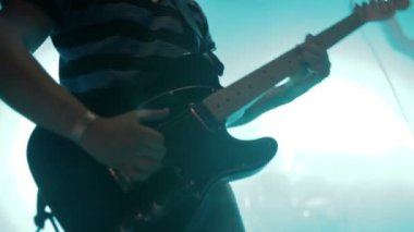 Gitarist sahnede elektro gitar çalıyor.