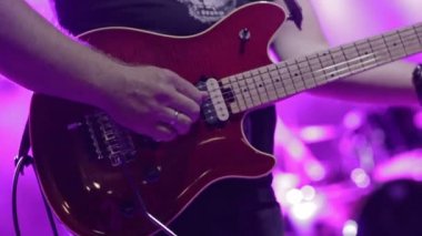 Gitarist sahnede elektro gitar çalıyor.