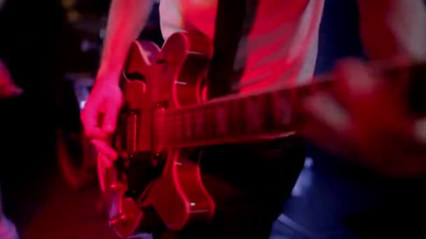 Гитарист играет на электрогитаре на концертной сцене — стоковое видео