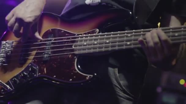 コンサートのステージで電気ギターを弾く男の低音のギタリスト — ストック動画
