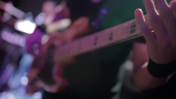 Hombre bajo guitarrista tocando la guitarra eléctrica en el escenario de concierto — Vídeo de stock