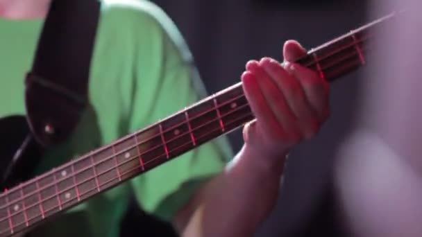 Hombre bajo guitarrista tocando la guitarra eléctrica en el escenario de concierto — Vídeo de stock