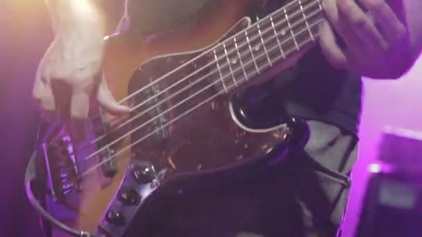 Hombre bajo guitarrista tocando la guitarra eléctrica en el escenario de concierto — Vídeo de stock