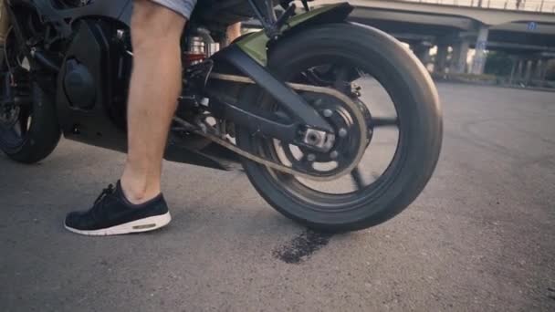 Motociclista deriva y se enciende una motocicleta en el asfalto — Vídeos de Stock