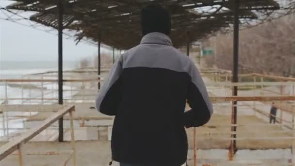 Homme court autour de la mer sur une plage abandonnée — Video