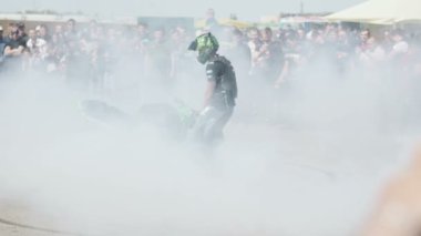 Sürücü motosiklet üzerinde gösteri yapıyor.