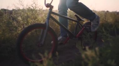 Bisikletçi gün batımında BMX 'iyle açıkta gezer.