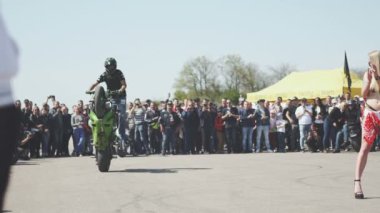 Sürücü motosiklet üzerinde gösteri yapıyor.