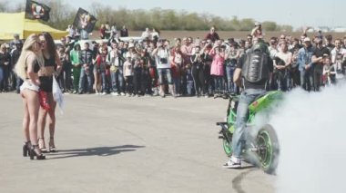 Sürücü motosiklet üzerinde gösteri yapıyor.