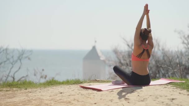 Young woman practicing yoga on the beach — Stock Video
