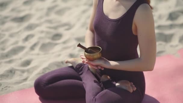 Jeune femme pratiquant le yoga sur la plage — Video