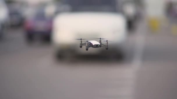 Lille drone racing quad copter flyver over biler i skumringen – Stock-video