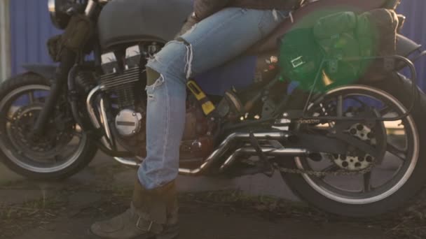 Motociclista senta-se em uma velha moto piloto de café — Vídeo de Stock