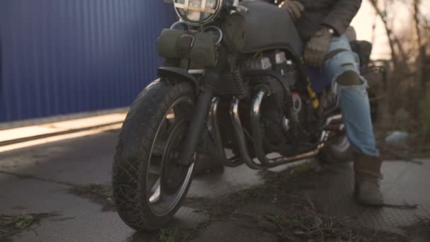 Motociclista senta-se em uma velha moto piloto de café — Vídeo de Stock