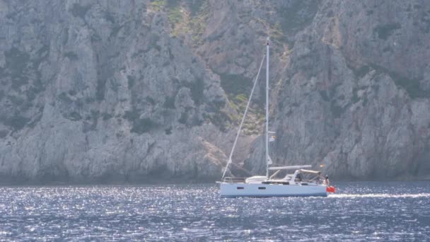 Akdeniz 'deki kayalık adanın yanında bir yat. — Stok video