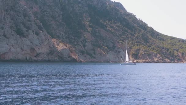 Яхта біля скелястого острова в середземному морі — стокове відео