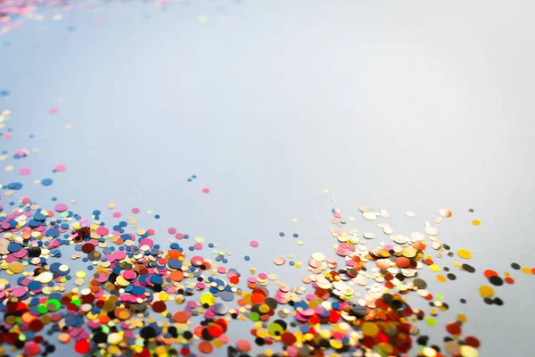 Confetti background, shiny dots bright colours on grey background, festive colours in focus