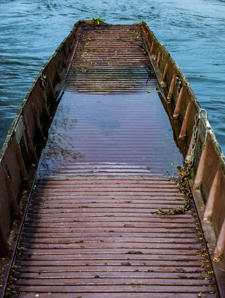 Brown abandoned row boat, vintage wooden boat sinking with leaves and water inside, damaged and left to rot rowing boat.