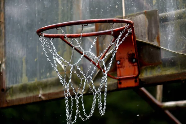 Outdoor basketball hoop and board damaged. It rains