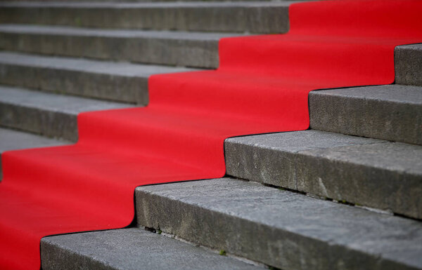 Elegant long red carpet on the wide steps of historic building